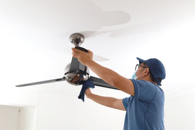 obsluha při čištění stropního ventilátoru