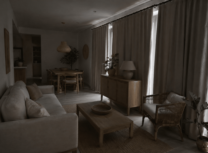 Een woonkamer die in een natuurlijke stijl is ingericht, maar met te zware gordijnen en te weinig natuurlijk licht